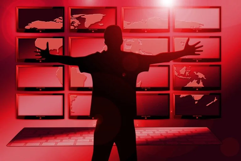 imagen de portada. Chico delante de pantallas en rojo. Cómo descargar vídeos de YouTube con VLC